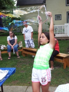 Lily uses a frame to make an enormous bubble during Mad Science Monday at Mentor Library