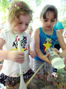 Evie and Maddie Smith pour glitter into a special Fairy Soup.